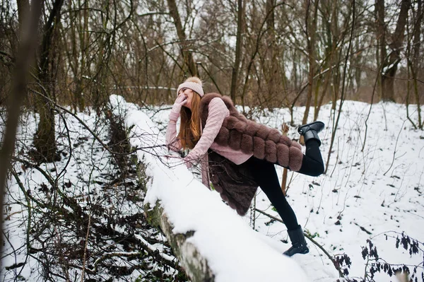 Stylisches Mädchen in Pelzmantel und Kopfbedeckung im Winterwald. — Stockfoto