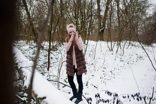 Menina elegante em casaco de pele e headwear na floresta de inverno . — Fotografia de Stock