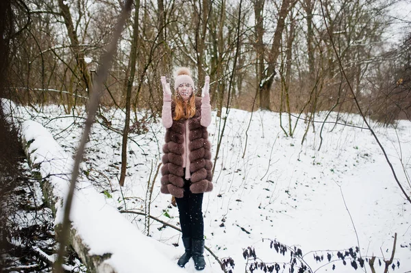 Fille élégante en manteau de fourrure et coiffure à la forêt d'hiver . — Photo