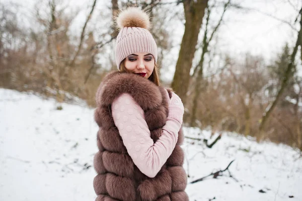 Stylish girl in fur coat and headwear at winter forest. — Stock Photo, Image
