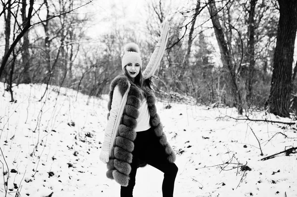 Κομψό κορίτσι στο γούνινο παλτό και πιλοποιία στο δάσος του χειμώνα. — Φωτογραφία Αρχείου
