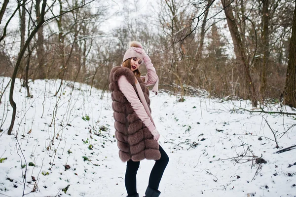 Fille élégante en manteau de fourrure et coiffure à la forêt d'hiver . — Photo