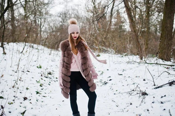 Stijlvolle meisje in bontjas en hoofddeksels bij winter forest. — Stockfoto