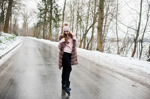 Stylowa dziewczyna w futrze i nakrycia głowy w zimowy dzień na drodze. — Zdjęcie stockowe