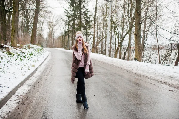 Стильная девушка в шубе и головном уборе в зимний день на дороге . — стоковое фото