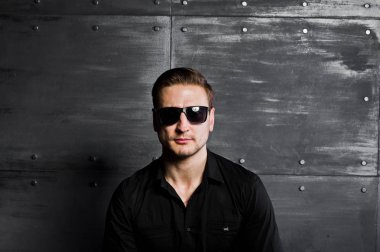 Şık adam portresi Studio giymek siyah gömlek ve gözlük bir