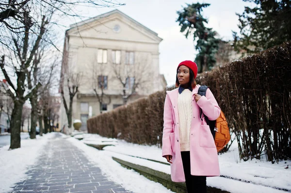 Chica afroamericana en sombrero rojo y abrigo rosa con mochila en — Foto de Stock