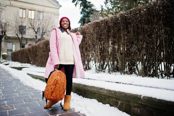 Chica afroamericana en sombrero rojo y abrigo rosa con mochila en — Foto de Stock