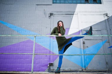 Genç kız renkli duvara karşı soğuk günde germe poz verdi.