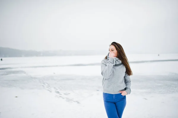 Забавная девушка носит свитер с капюшоном и джинсы, на замерзшем озере в wi — стоковое фото