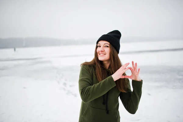 Lustiges Mädchen trägt langes grünes Sweatshirt, Jeans und schwarze Kopfbedeckung — Stockfoto