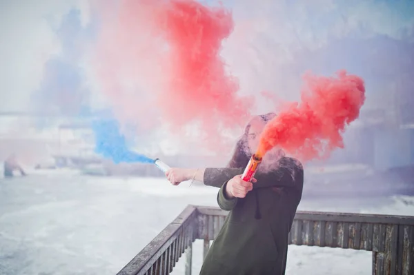 Ung flicka med blå och röd färgad rök bomb i händer. — Stockfoto