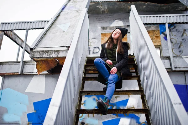 Mladá dívka opotřebení na dlouhou zelenou mikinu, džíny a černé headwe — Stock fotografie