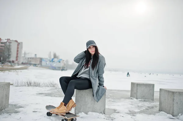 Menina morena elegante em gorro cinza, estilo de rua casual com skat — Fotografia de Stock