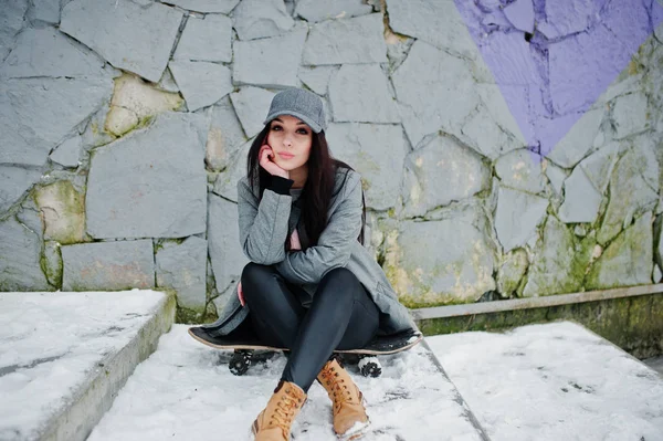 Menina morena elegante em gorro cinza, estilo de rua casual com skat — Fotografia de Stock