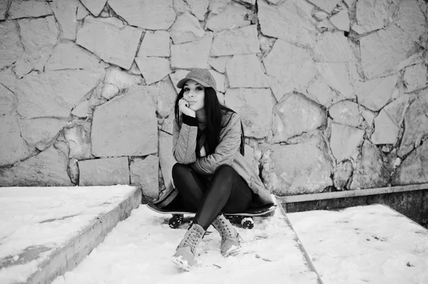 Κομψό κορίτσι μελαχρινή στο γκρι καπάκι, casual στυλ του δρόμου με skat — Φωτογραφία Αρχείου
