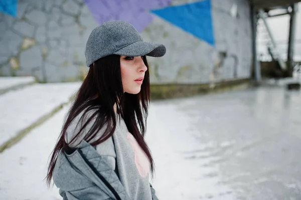 Chica morena con estilo en gorra gris, estilo casual en la calle en invierno — Foto de Stock