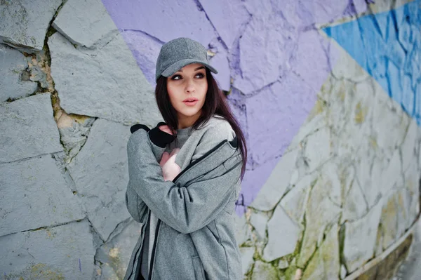 Chica morena con estilo en gorra gris, estilo casual en la calle en invierno —  Fotos de Stock