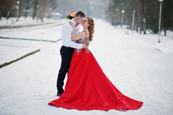 Increíble pareja en invierno bosque de cuento de hadas en el amor. Chica en rojo b — Foto de Stock