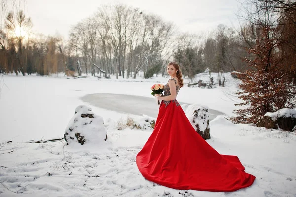 Hinreißende Mädchen mit Strauß im eleganten roten Kleid am Wintertag. — Stockfoto