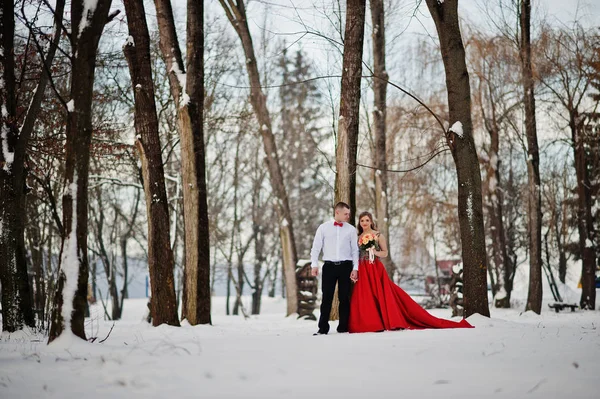 Increíble pareja en invierno bosque de cuento de hadas en el amor. Chica en rojo b — Foto de Stock