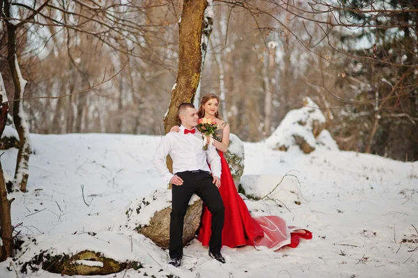 Increíble pareja en invierno bosque de cuento de hadas en el amor. Chica en rojo b —  Fotos de Stock