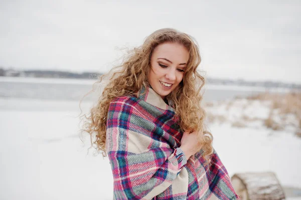 Chica rubia rizada en cuadros a cuadros contra el lago congelado en invierno —  Fotos de Stock