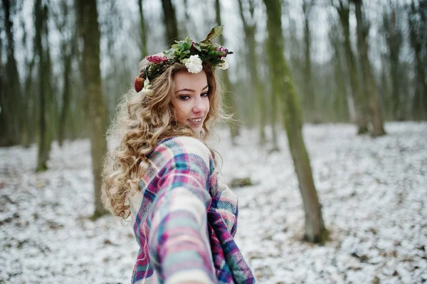 Krullend schattige blonde meisje met krans in geruite plaid op besneeuwde f — Stockfoto