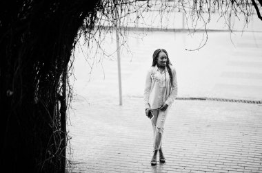 Şık Afro-Amerikan kız cep telefonu tutan dreads ile bir