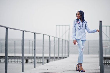 Şık Afro-Amerikan kız cep telefonu tutan dreads ile bir