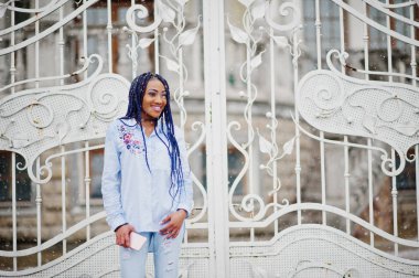 Şık Afro-Amerikan kız cep telefonu tutan dreads ile bir