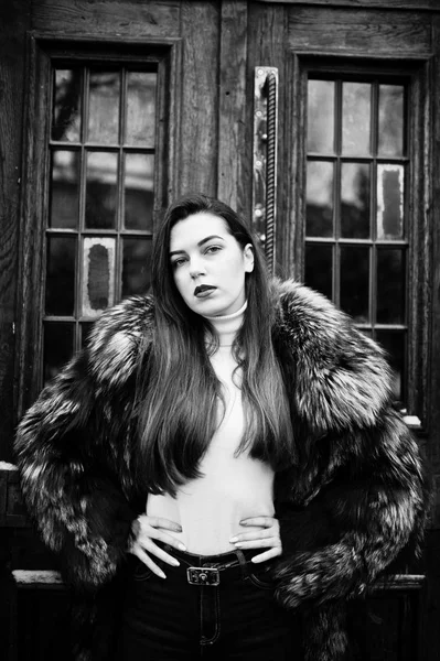古い木製のドアに対して緑の毛皮のコートのブルネットの少女. — ストック写真