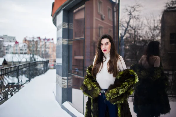 Brunette fille en manteau de fourrure vert à la rue de la ville contre la maison — Photo