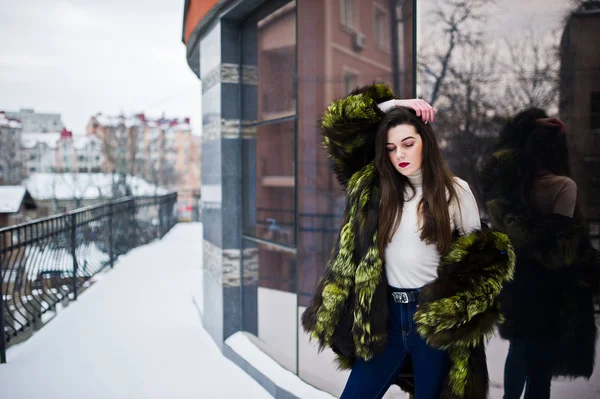 Brunette fille en manteau de fourrure vert à la rue de la ville contre la maison — Photo