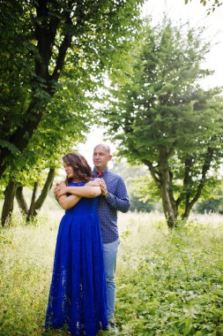Güzel çift yeşil park aşık. Mavi elbiseli kız.