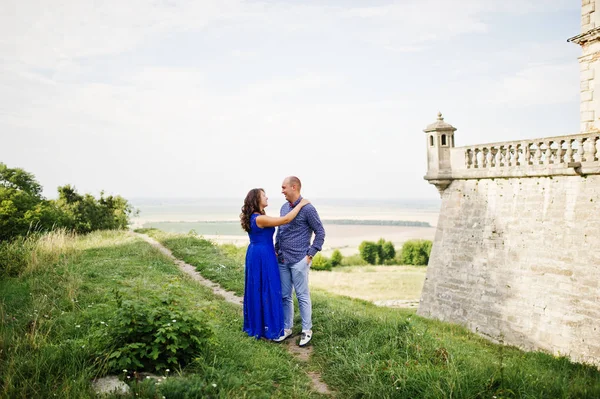 Encantador casal apaixonado contra o velho castelo. Menina em vestido azul . — Fotografia de Stock