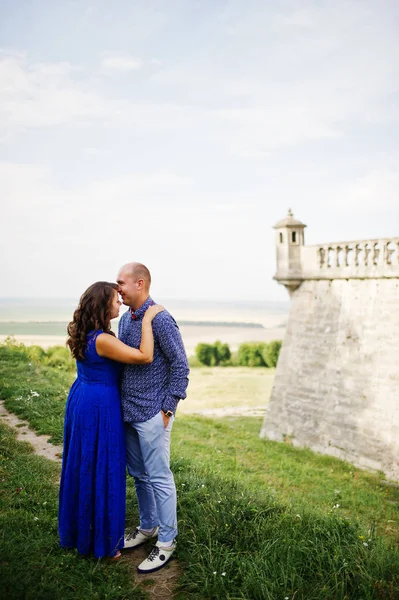 Hermosa pareja enamorada contra el viejo castillo. Chica en vestido azul . —  Fotos de Stock