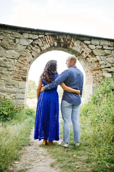 Hermosa pareja enamorada contra el viejo castillo. Chica en vestido azul . — Foto de Stock