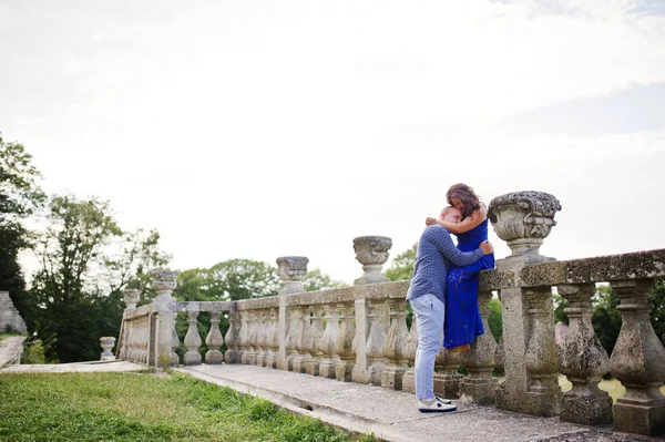 Bella coppia innamorata contro il vecchio castello. Ragazza in abito blu . — Foto Stock