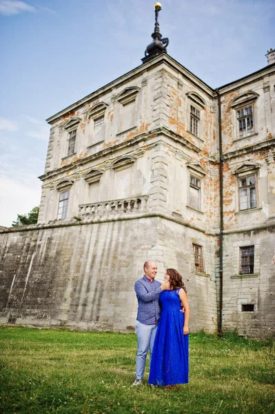 Encantador casal apaixonado contra o velho castelo. Menina em vestido azul . — Fotografia de Stock