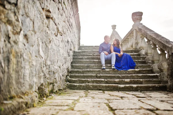 Encantador casal apaixonado contra o velho castelo. Menina em vestido azul . — Fotografia de Stock