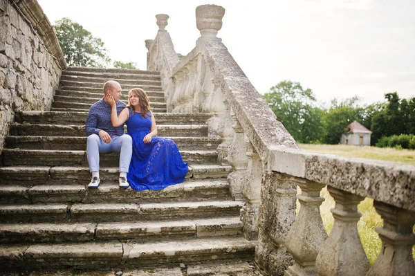 Encantador casal apaixonado contra o velho castelo. Menina em vestido azul . — Fotografia de Stock