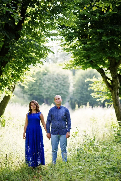 Casal encantador apaixonado no parque verde. Menina em vestido azul . — Fotografia de Stock