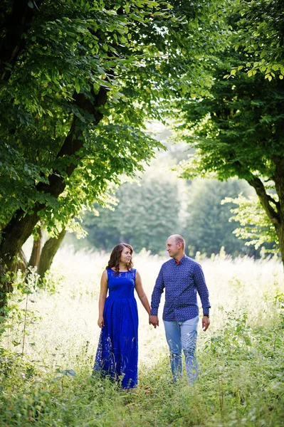 Casal encantador apaixonado no parque verde. Menina em vestido azul . — Fotografia de Stock