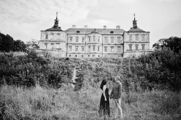 Krásný pár v lásce proti starý hrad. Dívka v modrých šatech. — Stock fotografie