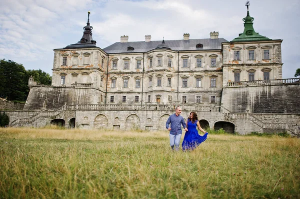 Encantador casal apaixonado contra o velho castelo. Menina em vestido azul . — Fotografia de Stock