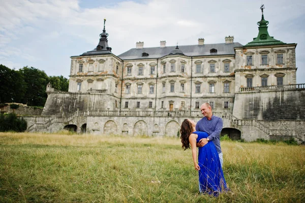 Encantador casal apaixonado contra o velho castelo. Menina em vestido azul . — Fotografia de Stock