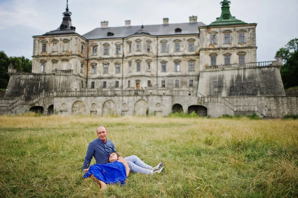 Krásný pár v lásce proti starý hrad. Dívka v modrých šatech. — Stock fotografie