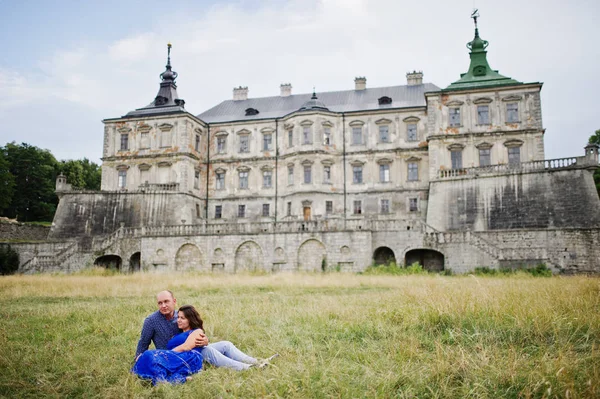 Encantador casal apaixonado contra o velho castelo. Menina em vestido azul . — Fotografia de Stock