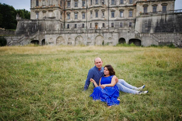 Encantador casal apaixonado contra o velho castelo. Menina em vestido azul . — Fotografia de Stock